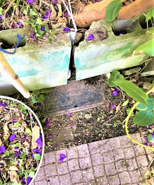 花壇で開けられない状態の水道メーターボックス