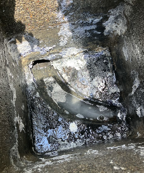 排水桝から超高圧洗浄の作業中